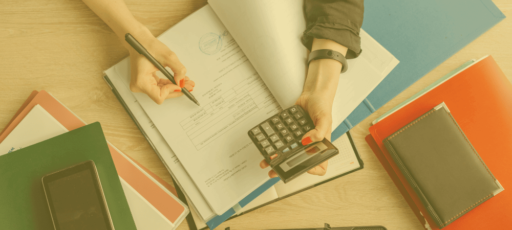 Woman with an open notebook holding a pen and a calculator